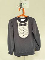 Front view of sweatshirt showing tuxedo print and overall condition
