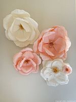 Four crepe paper wall flowers arranged on wall