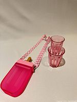 Water bottle with strap beside two cups