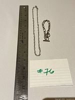 Necklace and bracelet alongside ruler for scale