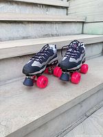 Both roller skates on stone steps showing overall appearance, wheels, toe stops, colors