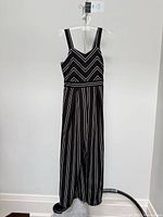 Front view of the jumpsuit on hanger showing full length, stripe pattern and silhouette