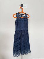 Front view of navy lace dress on hanger