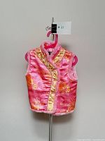 Front view of toddler pink and gold brocade vest with faux fur trim on hanger