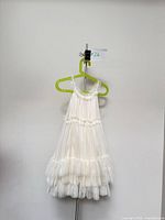Front view of ivory tulle flower girl dress on hanger