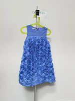 Front view of sleeveless light blue Mayoral dress on hanger showing rosette skirt and tulle bodice