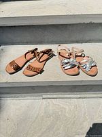 Both pairs of sandals side by side on stone surface