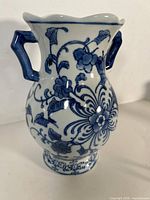 front view of blue and white porcelain vase with two handles and floral design