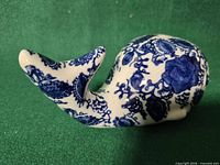 Left profile of blue and white porcelain whale coin bank