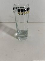 Front view of tall clear shot glass showing full body and decorative band