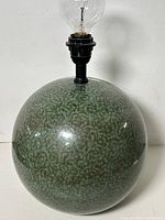 Front view of mottled green spherical ceramic lamp base with socket