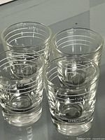 Four Dominion Glass shot glasses showing measurement markings