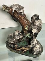 Full view of porcelain raccoon family figurine on stump