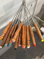 Full set of 12 fondue forks displaying handles and colored tips