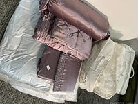 Full set in packaging including white sheet bundle and mauve comforter bundle
