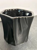 Front view of glossy black hexagonal porcelain vase