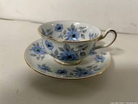 Teacup on saucer, side view showing pattern and gold rim