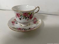 Pink rose pattern teacup and saucer, gold trim visible