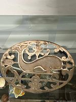 Top view of oval silver-plate trivet with whale cut-out design
