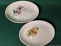 Two Gien oval plates showing distinct floral designs and fluted borders
