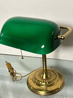 Full view of lamp showing green glass shade, brass base, pull chain, power cord