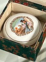 Jar inside open brocade box showing hand-painted lid scene