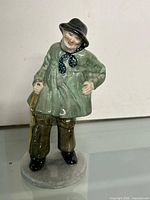 Full view of figurine showing pose and attire
