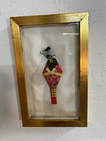 Full view of framed origami doll artwork