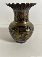 Front view showing oxidized brass surface and gold floral etching