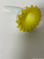 Top view showing yellow ruffled rim and white opaline exterior