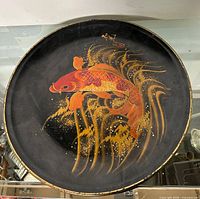 Full view of round black lacquer tray with koi design