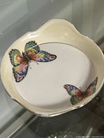 Top view of porcelain dish showing two colourful butterflies and rim design