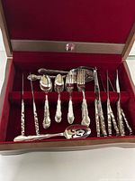 Open chest showing flatware arranged in red velvet slots