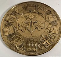 Front view of the brass Canadian provinces wall plaque showing central maple leaves and provincial shields