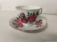 Front view of teacup on saucer showing floral pattern and gold trim