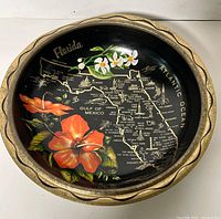 Full view of tin bowl showing map, flowers, and gold rim