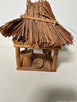 Front angled view showing overall hut structure and straw roof