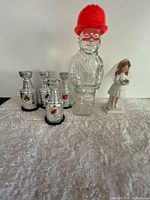 Group shot of all six items: four Stanley Cups, Mennen bottle, porcelain figurine