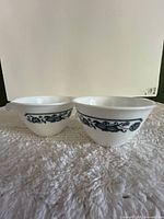 Two white bowls side by side showing blue floral band pattern