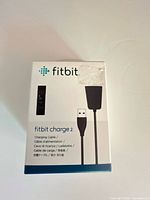 Front of boxed Fitbit Charge 2 charging cable