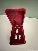 Necklace and earrings displayed in red velvet box