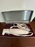 Electric knife handle in case with cord coiled
