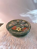 stack of four green divided plates showing overall style and quantity