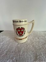Front view of ceramic stein showing Harvard crest, text on rim, gold trim