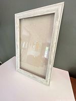 Front angled view of frame showing whitewashed wood and glass front