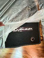 Front driver mat showing Lexus RX logo, black carpet, grommet