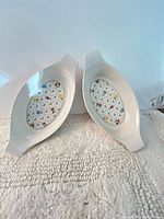 Top view of both oval white ceramic baking dishes showing floral interiors