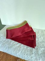 Stack of folded red napkins with green and gold borders