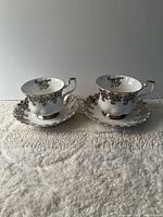 front view of both teacups on saucers displaying floral trim and shape