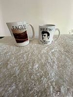 Front view of both mugs showing Eagles Tour 2008 and BREW Elvis graphics